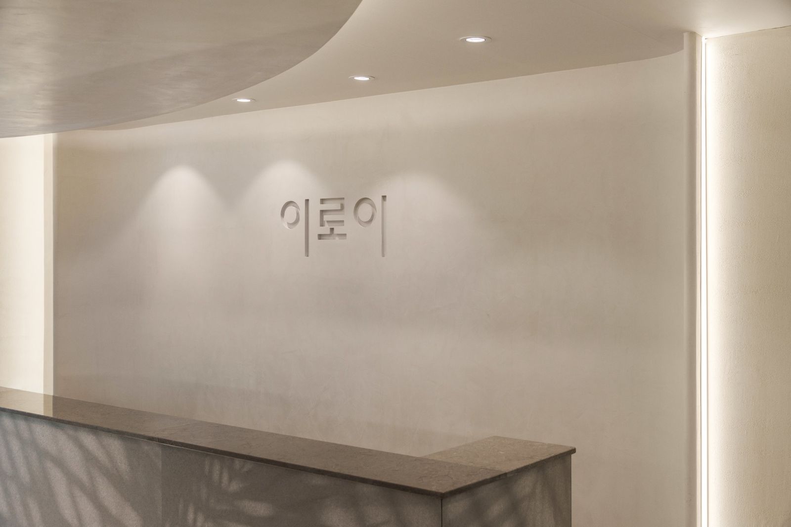 접수 데스크 뒤 벽에 새겨진 이로이 글자